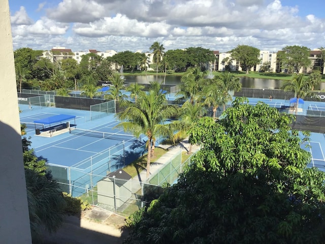 view of tennis court with a water view