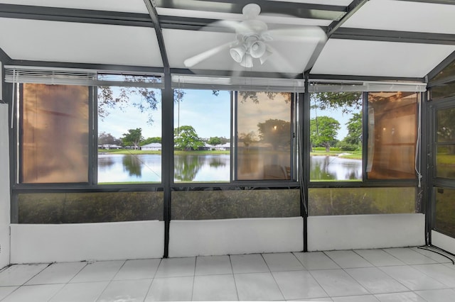 unfurnished sunroom featuring ceiling fan and a water view