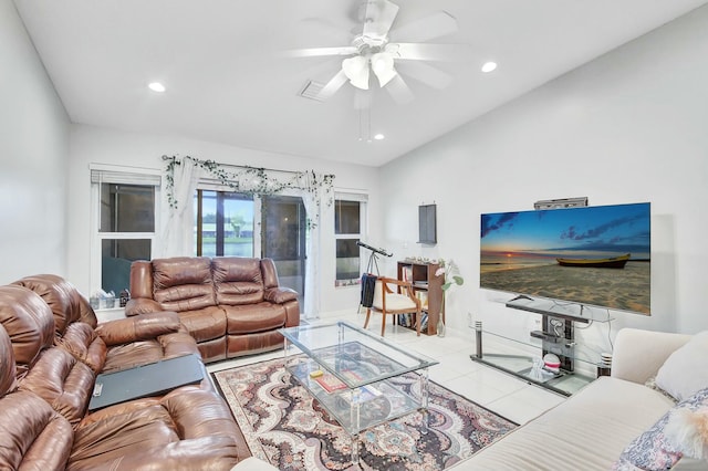 living room with ceiling fan, light tile patterned floors, and vaulted ceiling