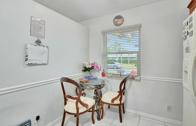 dining area featuring light tile patterned floors and a textured ceiling