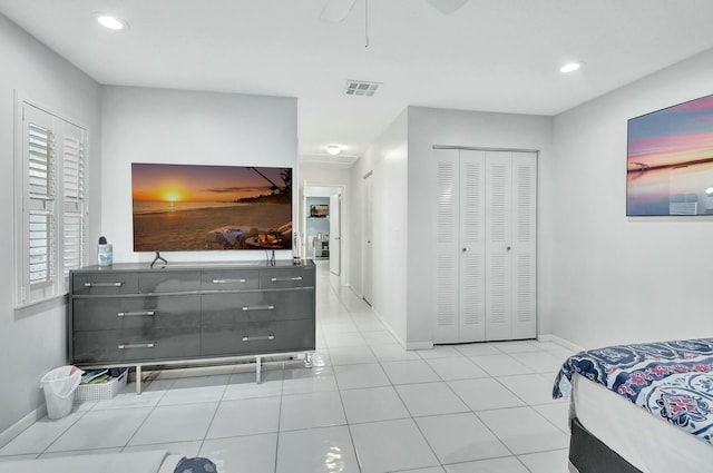 bedroom featuring light tile patterned floors, a closet, and ceiling fan