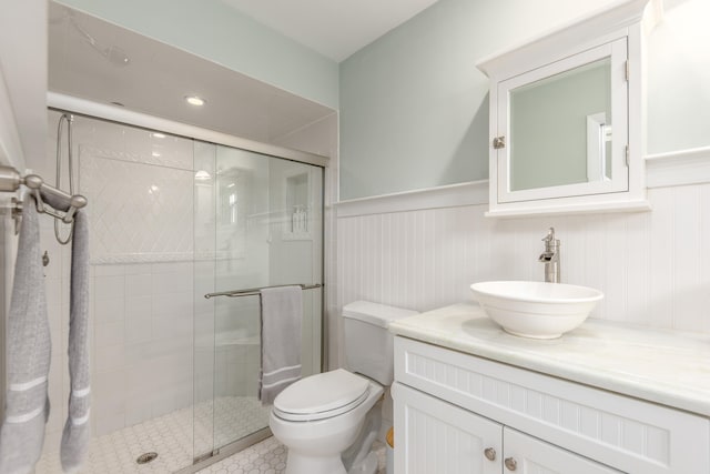 bathroom with vanity, toilet, and a shower with door