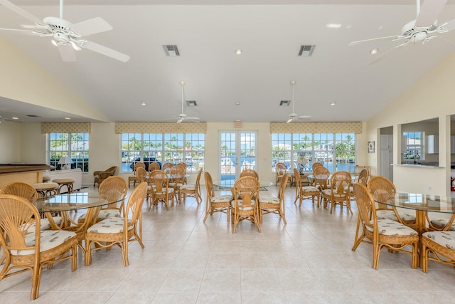 tiled dining area featuring vaulted ceiling, a wealth of natural light, and ceiling fan