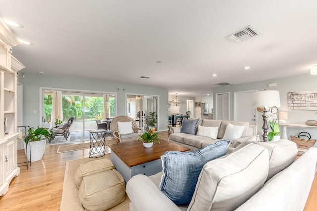 living room featuring a chandelier and light hardwood / wood-style floors