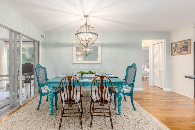 dining area featuring light wood-type flooring and a notable chandelier