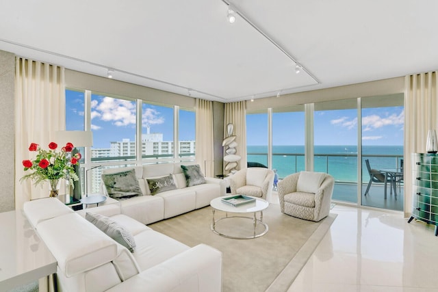 sunroom featuring a water view and track lighting