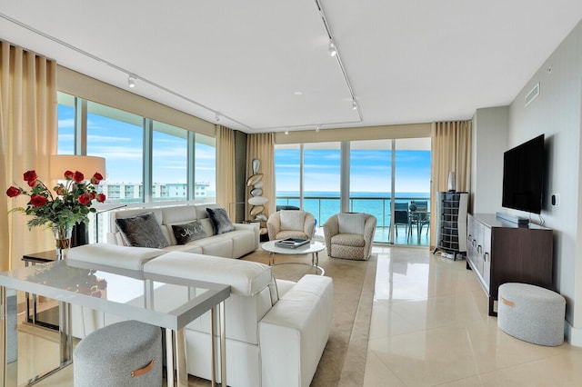 living room with a wealth of natural light, light tile patterned floors, and track lighting