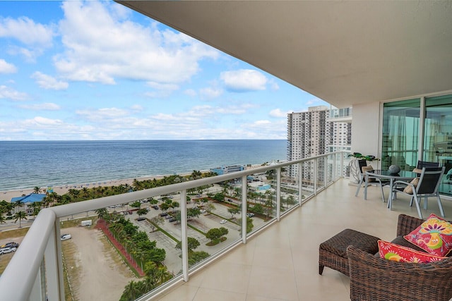 balcony featuring a water view and a beach view