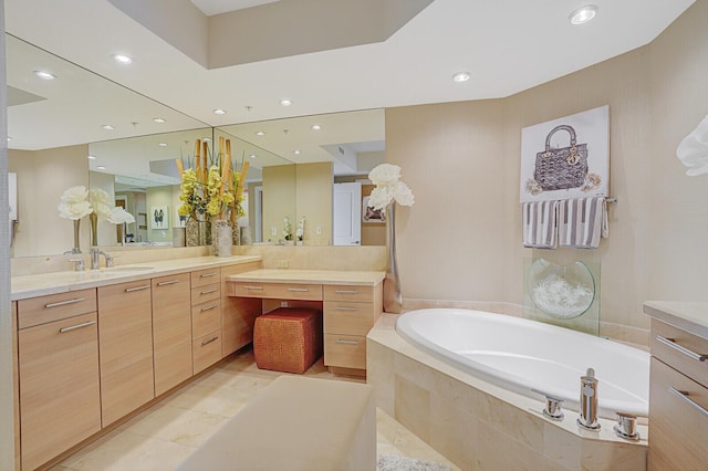 bathroom featuring tile patterned floors, vanity, and tiled bath