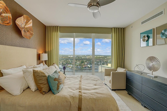 bedroom featuring ceiling fan and a water view