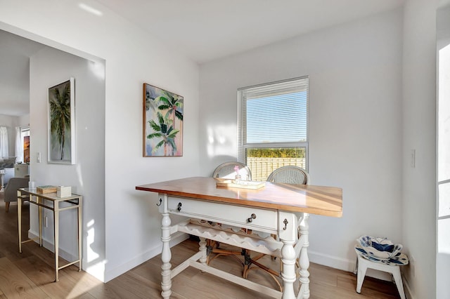 dining area with light hardwood / wood-style flooring and beverage cooler