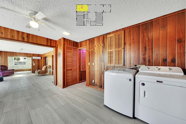 laundry area with wood walls, ceiling fan, a textured ceiling, and independent washer and dryer