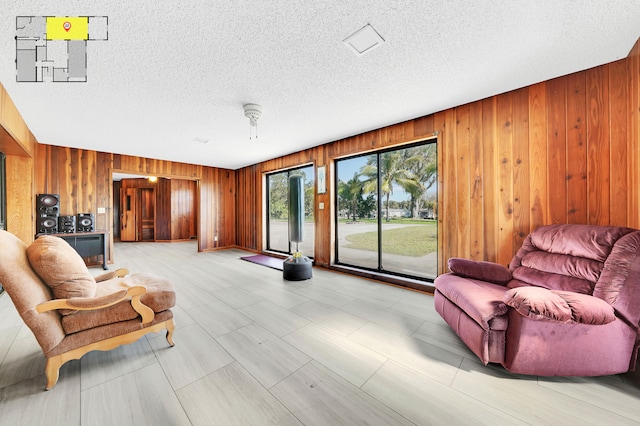 sitting room with wooden walls and a textured ceiling