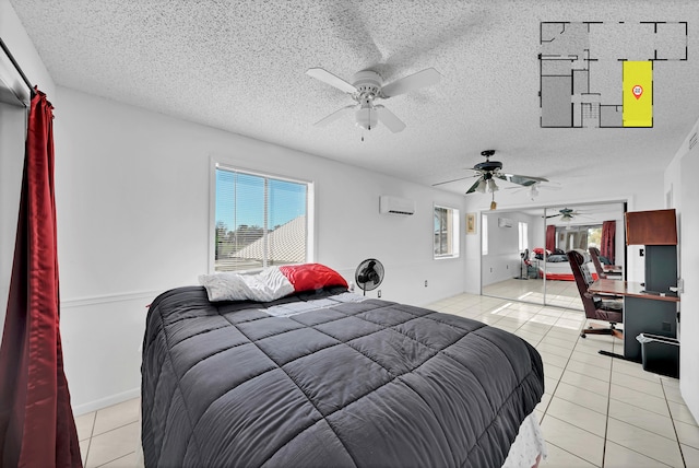 bedroom featuring a textured ceiling, ceiling fan, light tile patterned floors, and a wall mounted air conditioner