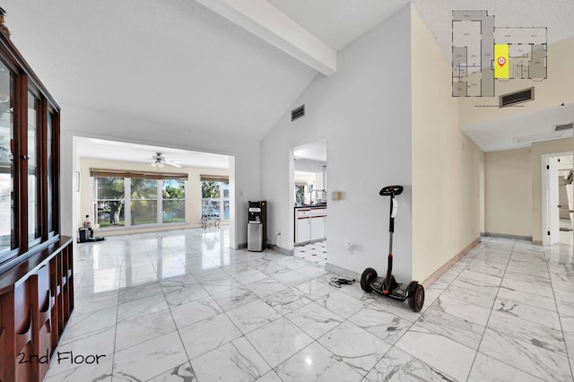 foyer entrance with beam ceiling, a textured ceiling, high vaulted ceiling, and ceiling fan