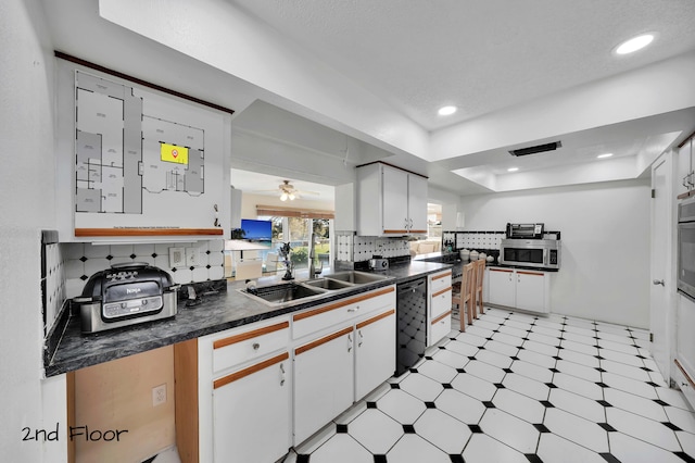 kitchen with ceiling fan, sink, tasteful backsplash, white cabinets, and appliances with stainless steel finishes