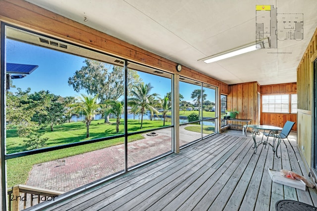 unfurnished sunroom featuring a water view