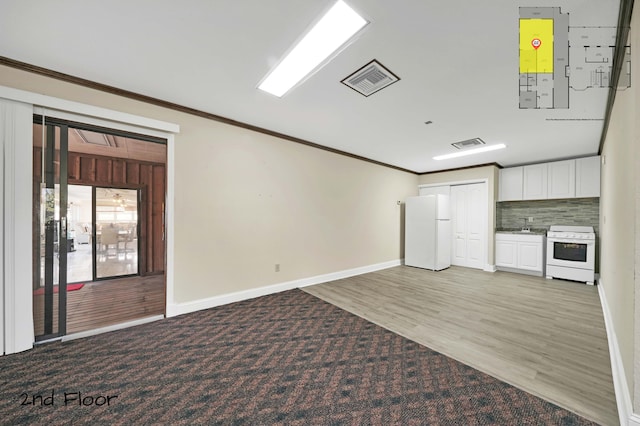 spare room with light hardwood / wood-style floors and crown molding