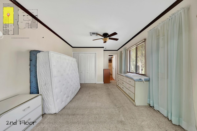 bedroom featuring a closet, light colored carpet, ceiling fan, and crown molding