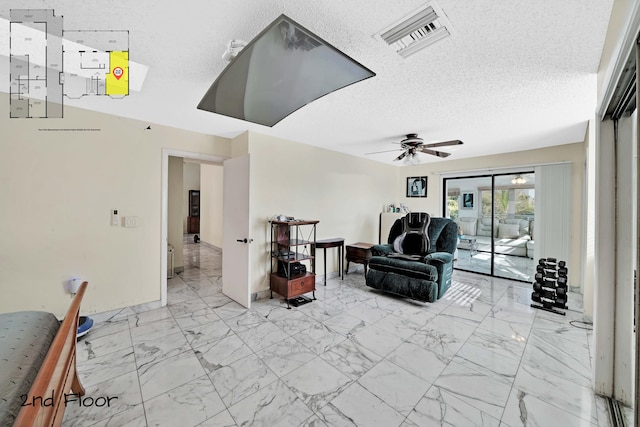 living room featuring a textured ceiling and ceiling fan