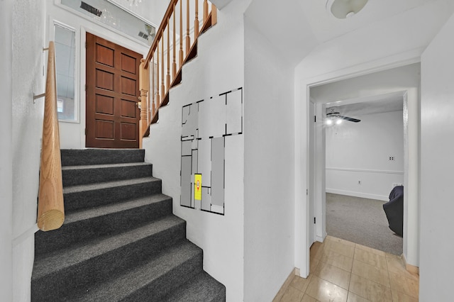 stairway featuring carpet flooring and ceiling fan