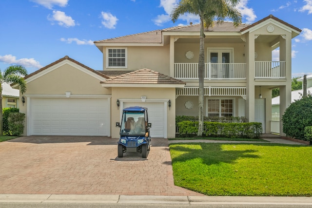 view of front of home with a front yard, a balcony, and a garage