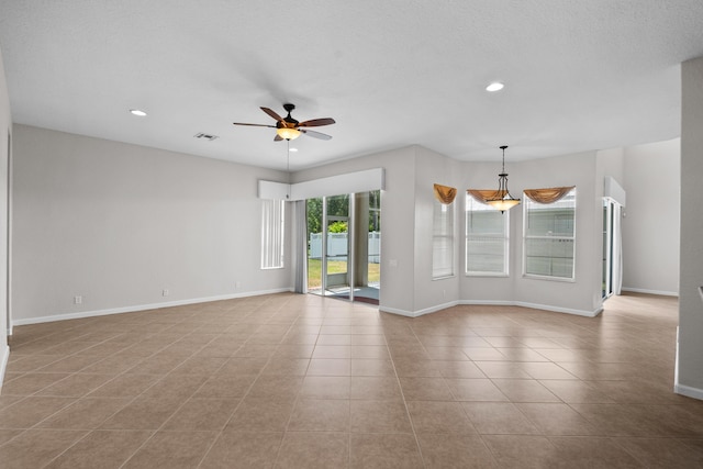 tiled spare room with ceiling fan and a textured ceiling