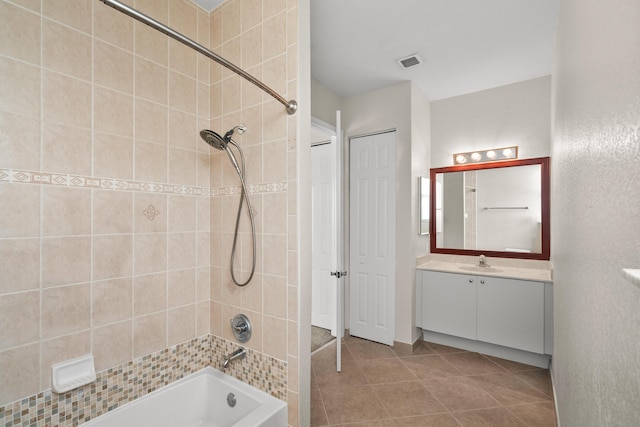 bathroom with tiled shower / bath and vanity