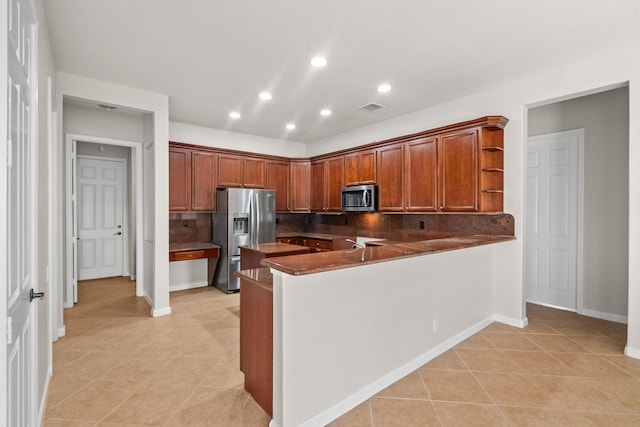 kitchen featuring light tile patterned floors, stainless steel appliances, backsplash, and kitchen peninsula