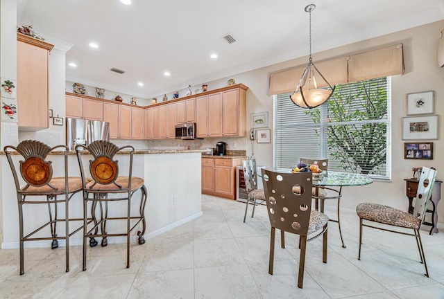 kitchen featuring light brown cabinets, beverage cooler, stainless steel appliances, light stone counters, and pendant lighting