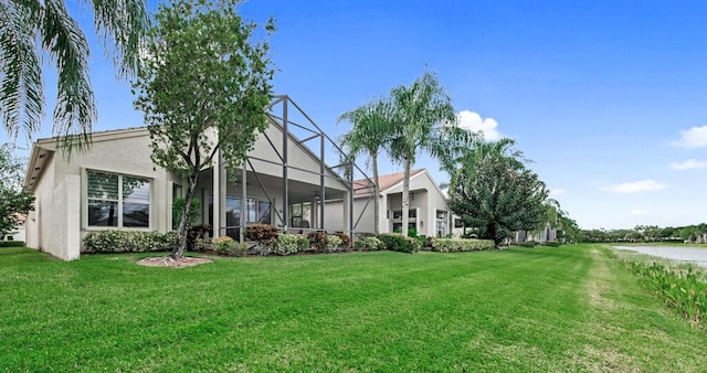 back of property with a yard and a lanai