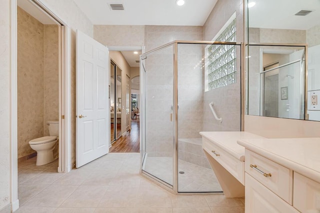 bathroom featuring hardwood / wood-style floors, toilet, an enclosed shower, and vanity