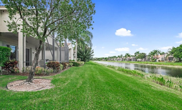 view of yard featuring a lanai and a water view