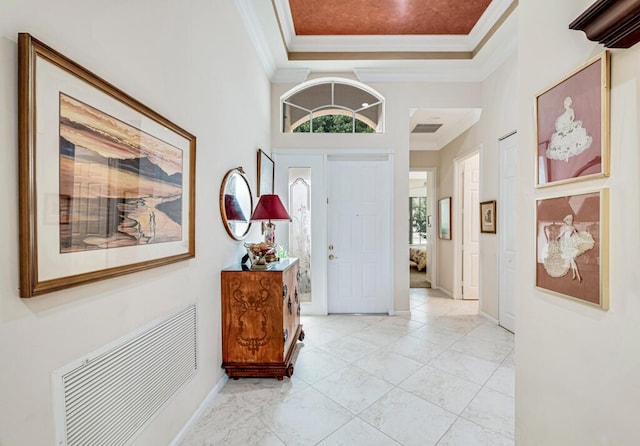 foyer featuring a towering ceiling and ornamental molding