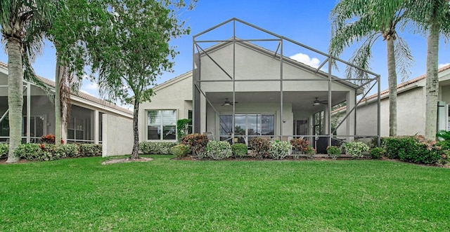 back of property with a lawn, glass enclosure, and ceiling fan