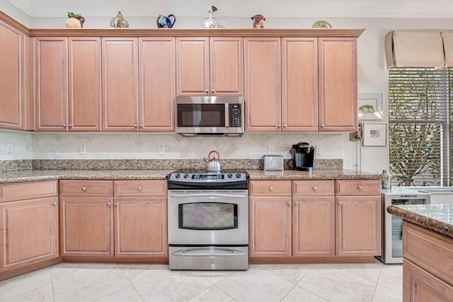 kitchen with backsplash, wine cooler, light stone countertops, and appliances with stainless steel finishes