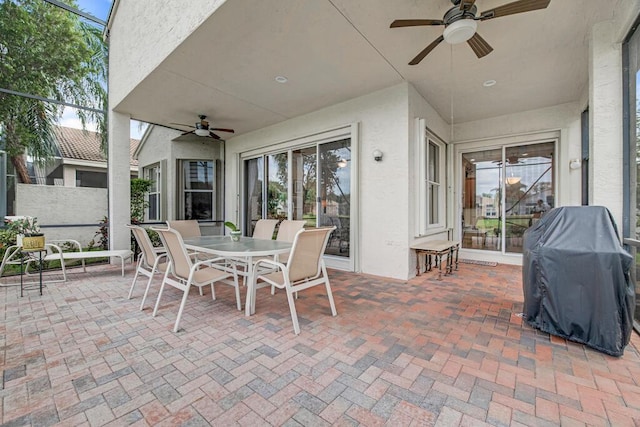 view of patio featuring glass enclosure, ceiling fan, and a grill