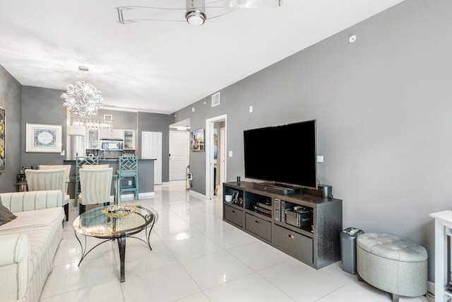 tiled living room featuring an inviting chandelier