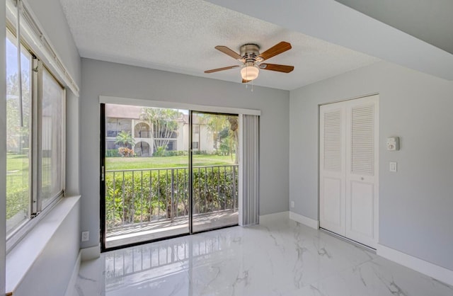 interior space with ceiling fan and a textured ceiling