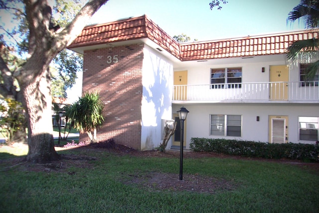 1225 NW 21st St Unit 3506, Stuart, FL 34994 - view of front of home with brick siding, a front yard, and stucco siding