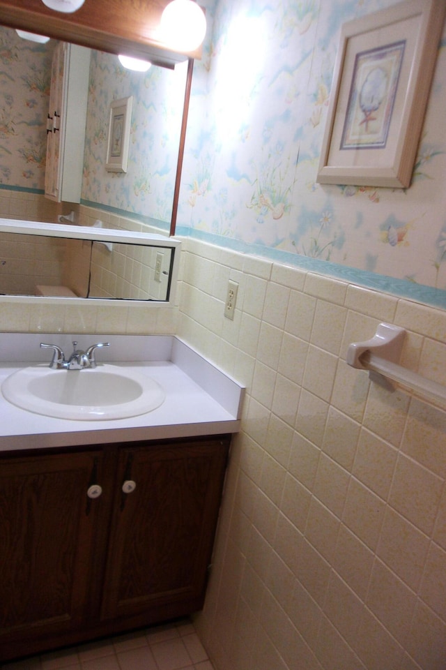 bathroom featuring tile patterned flooring, vanity, and tile walls