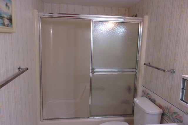 bathroom with toilet and enclosed tub / shower combo