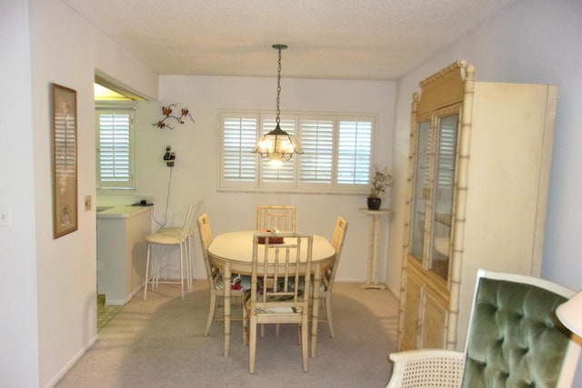 carpeted dining space featuring a textured ceiling, a wealth of natural light, and an inviting chandelier