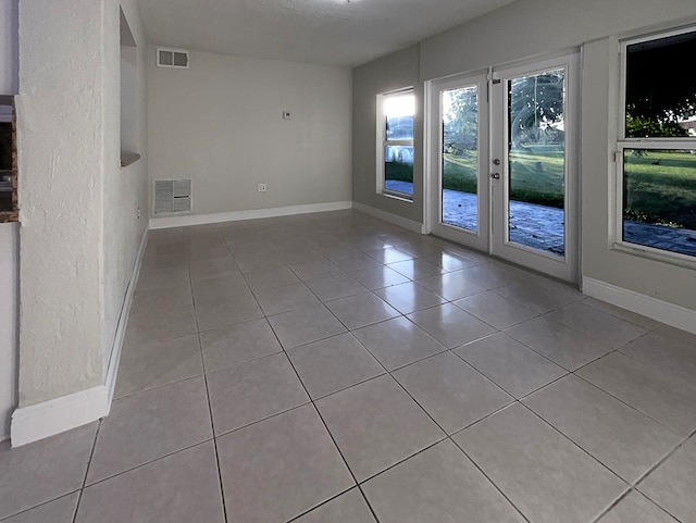 unfurnished room with french doors and light tile patterned flooring