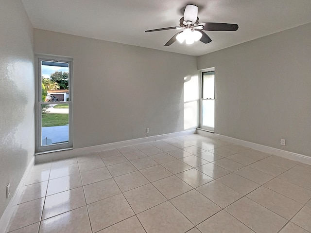 tiled spare room featuring ceiling fan