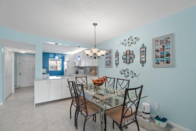 dining area featuring sink, a textured ceiling, and a notable chandelier