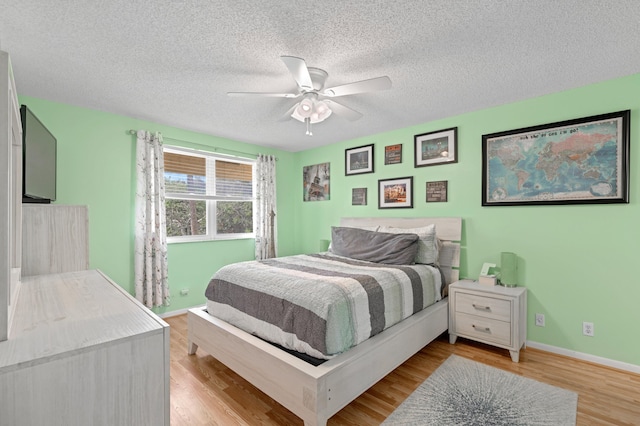 bedroom featuring a textured ceiling, light hardwood / wood-style floors, and ceiling fan