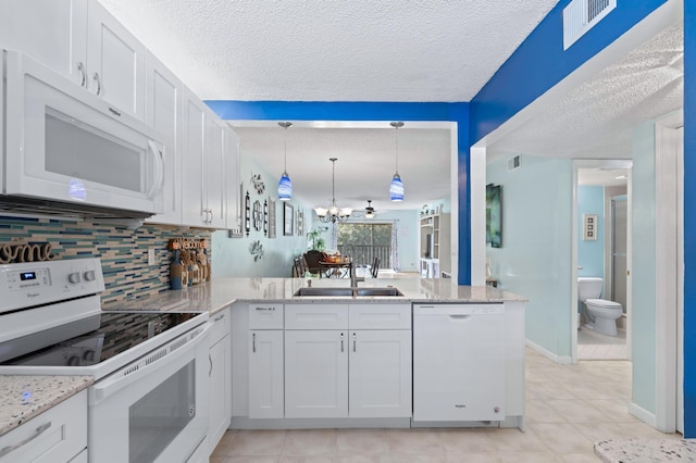 kitchen featuring white cabinetry, sink, white appliances, and kitchen peninsula