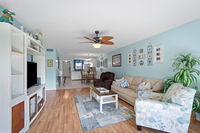 living room featuring ceiling fan and light hardwood / wood-style flooring