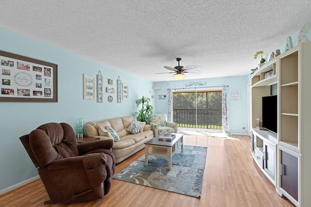 living room with hardwood / wood-style floors, ceiling fan, and a textured ceiling